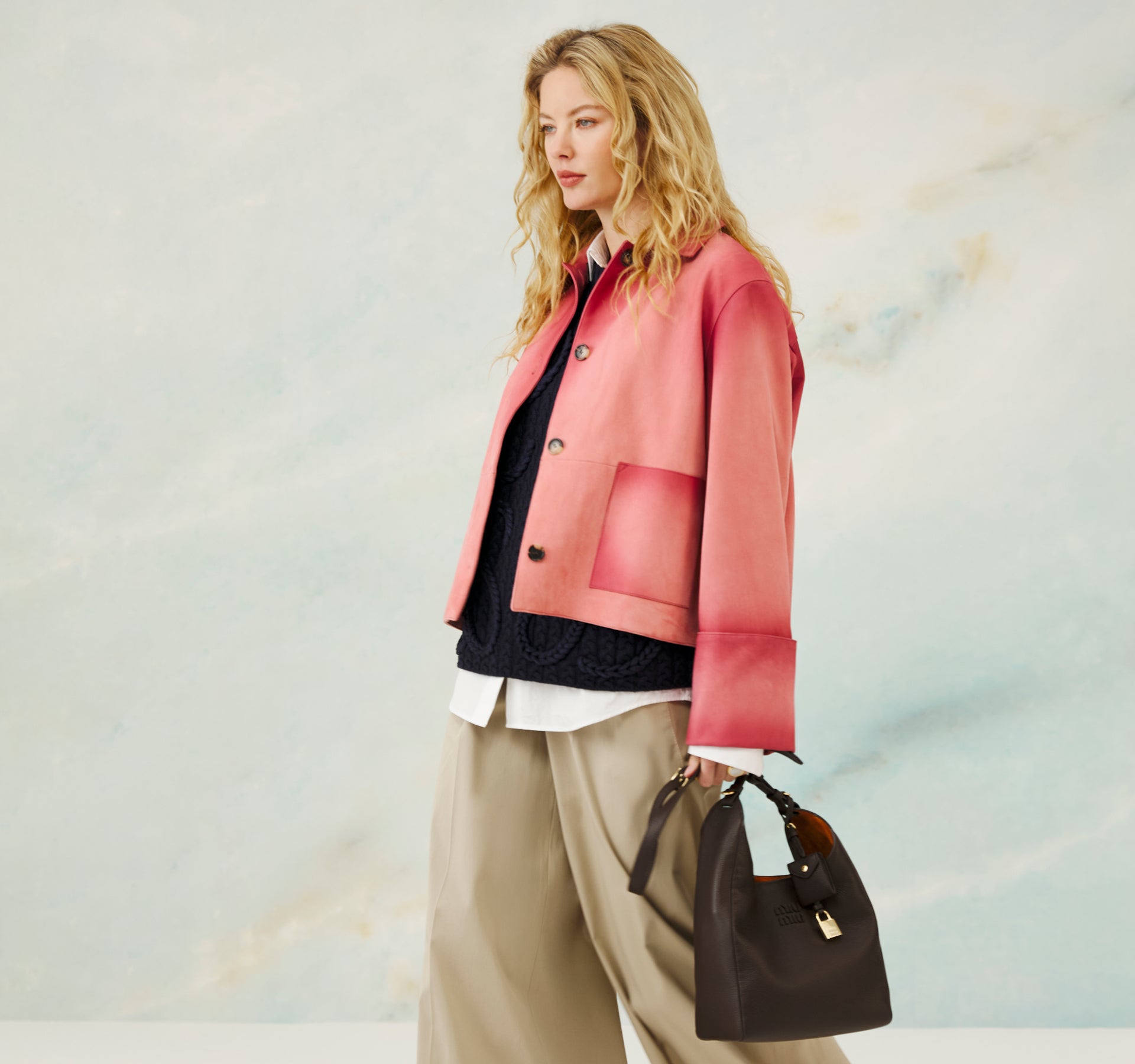 Woman wearing a pink jacket with a blurred abstract background