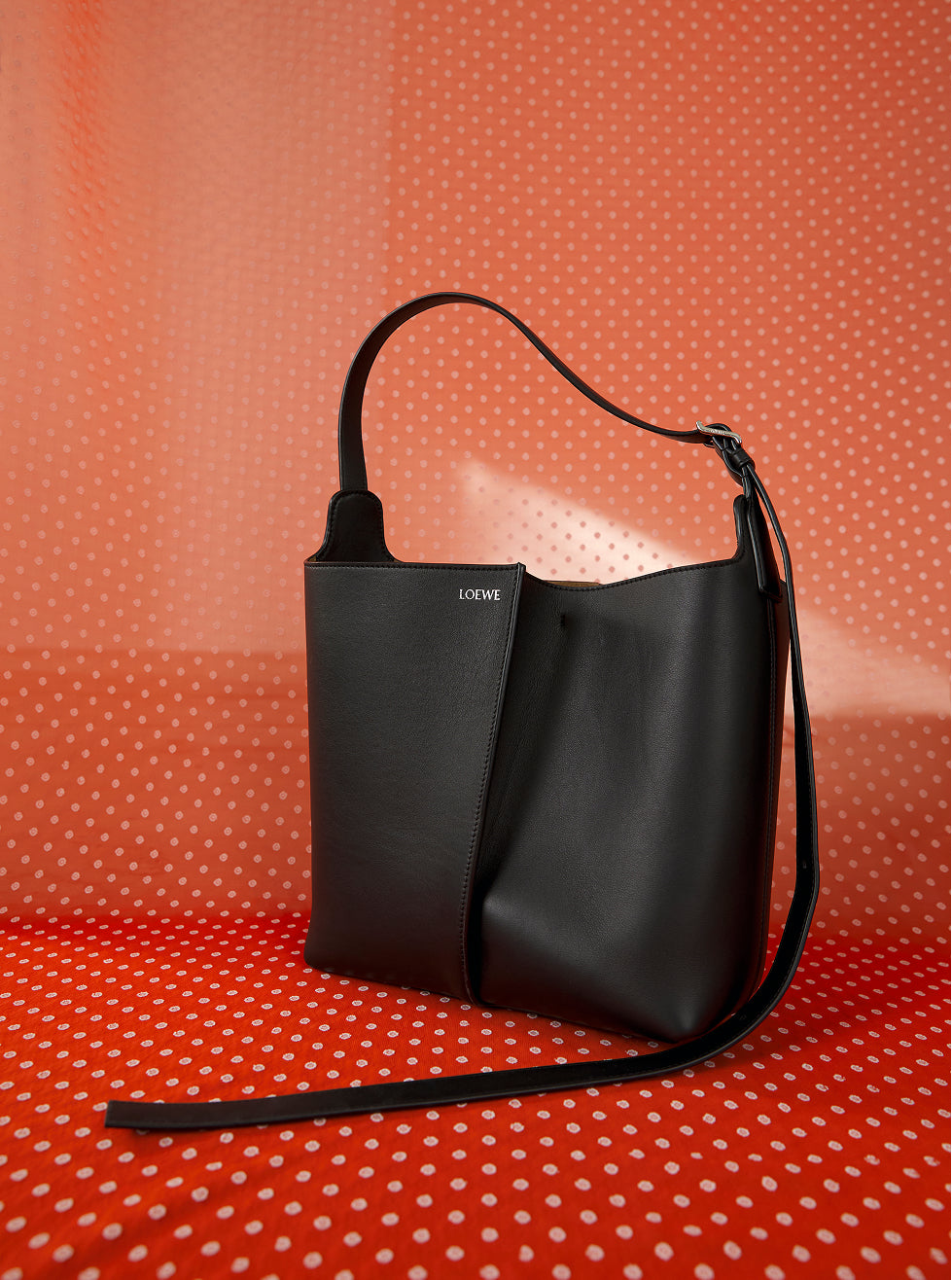 Black handbag on a red polka dot background