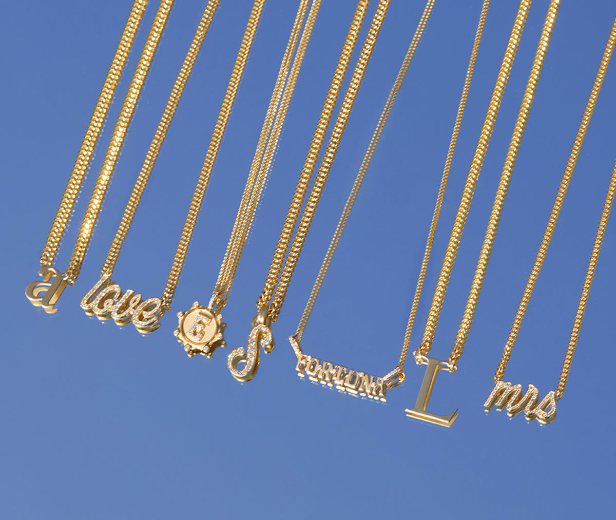 Gold necklaces in front of the blue background
