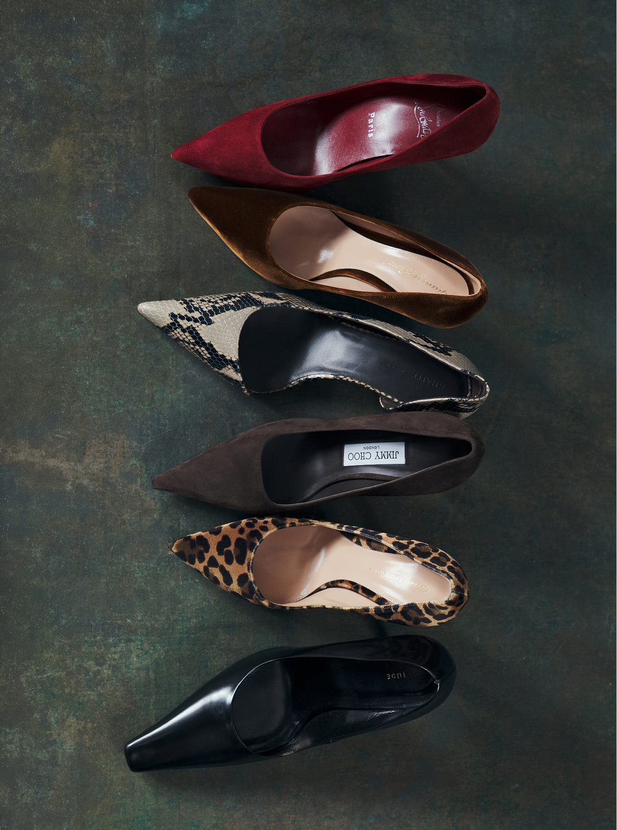 Image taken from the top of six different colored shoes in front of a green background.