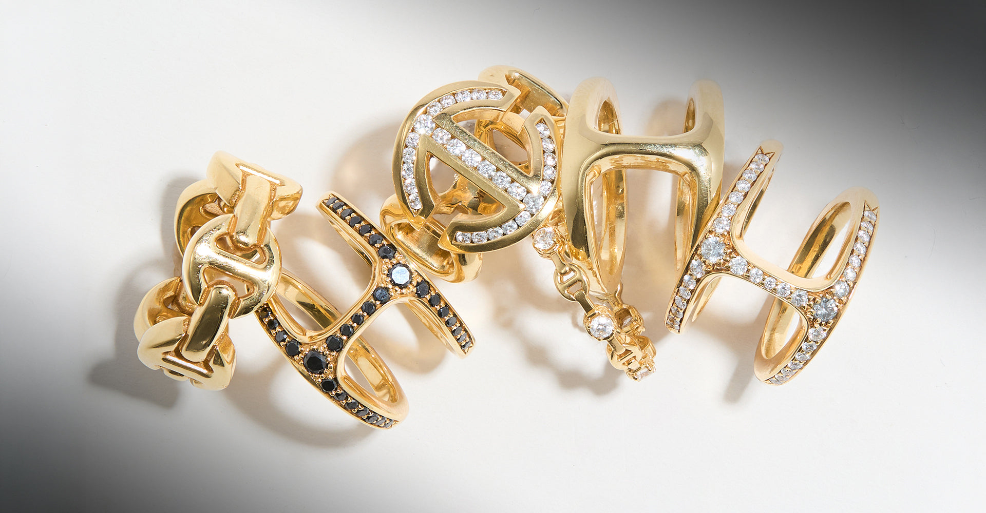 Gold rings with intricate designs on a gradient background