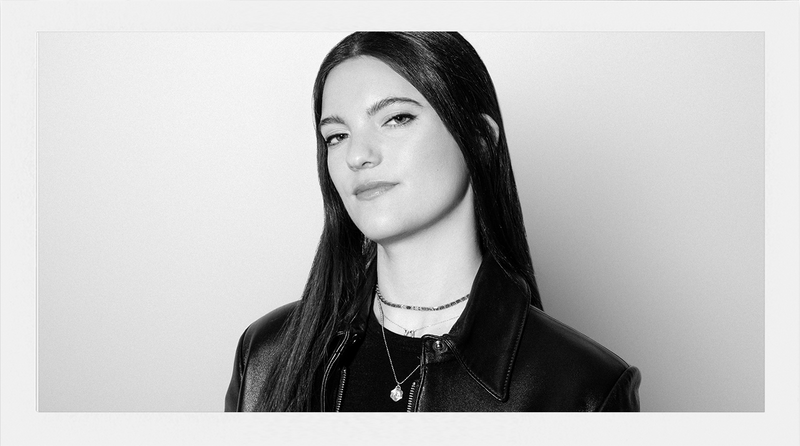 Black and white portrait of a woman with long hair on a plain background