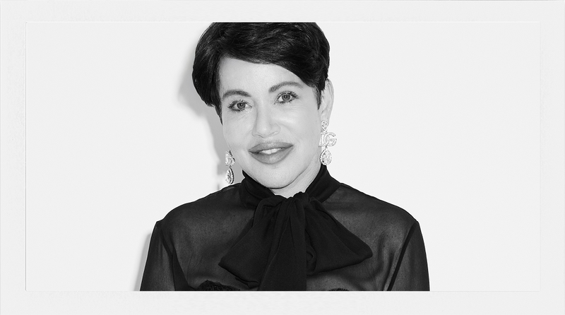 Black and white portrait of a woman wearing a black blouse with a bow neckline.