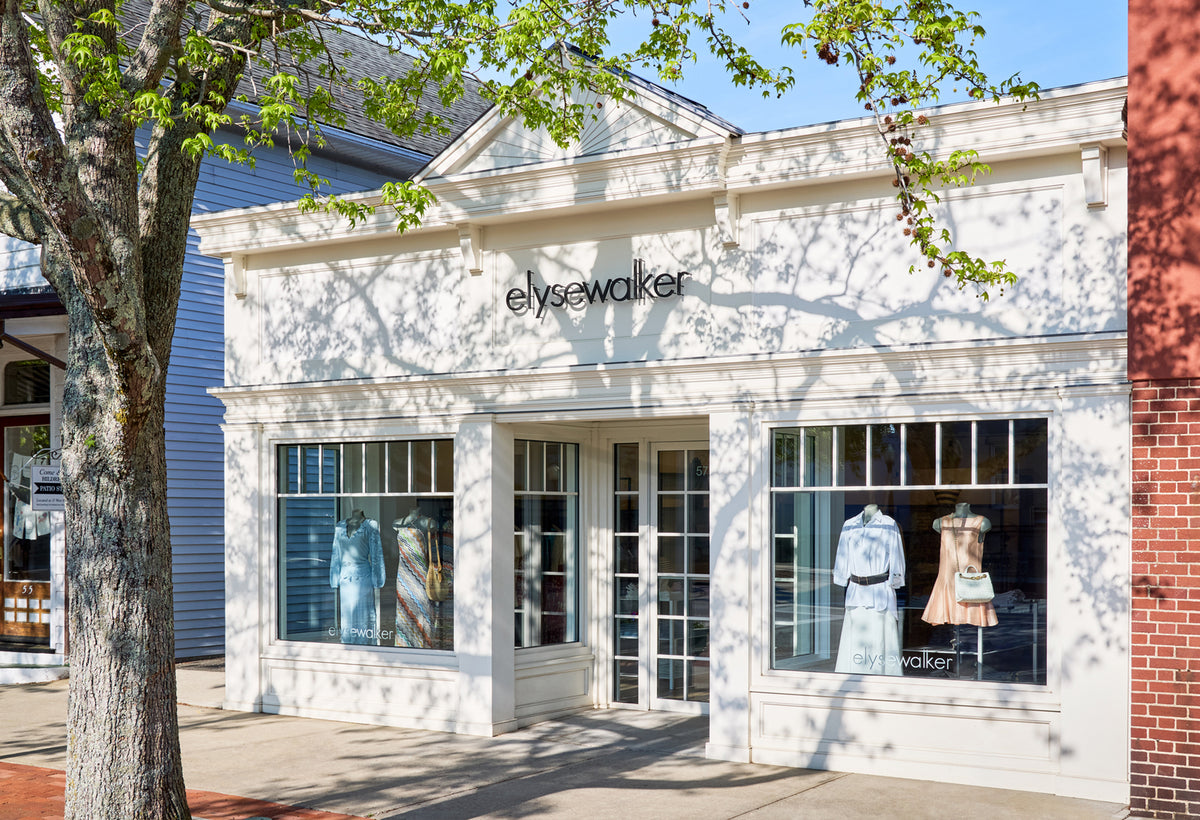 Elyse Walker store front with mannequins in windows on a sunny day.